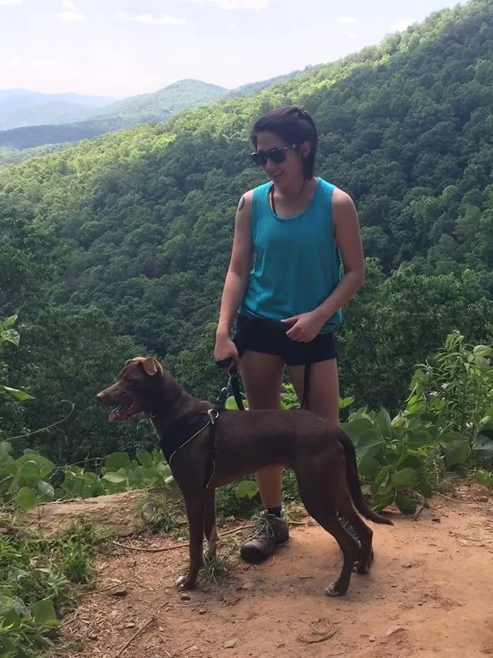 Nicole, a Hooman on Demand walker, hiking with a dog