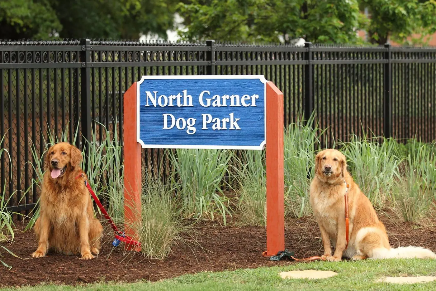 Two dogs at the North Garner Dog Park sign